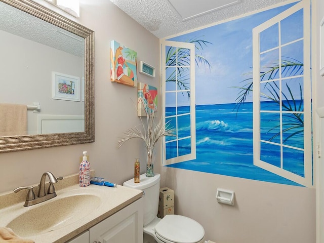 bathroom with vanity, a textured ceiling, and toilet