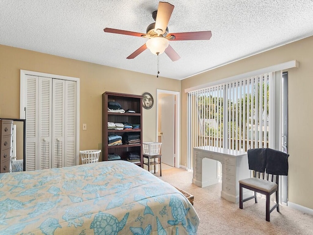 carpeted bedroom featuring ceiling fan, a closet, and a textured ceiling