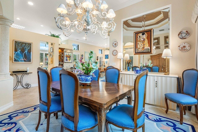 dining room with crown molding, a chandelier, a raised ceiling, and ornate columns