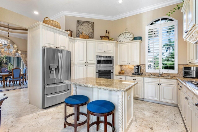 kitchen featuring tasteful backsplash, ornamental molding, a center island, and appliances with stainless steel finishes