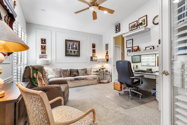 carpeted office space with ceiling fan, a healthy amount of sunlight, and a textured ceiling