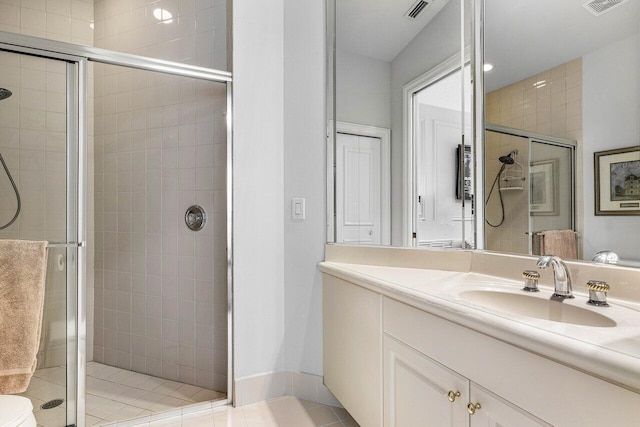 bathroom featuring tile patterned flooring, vanity, and walk in shower