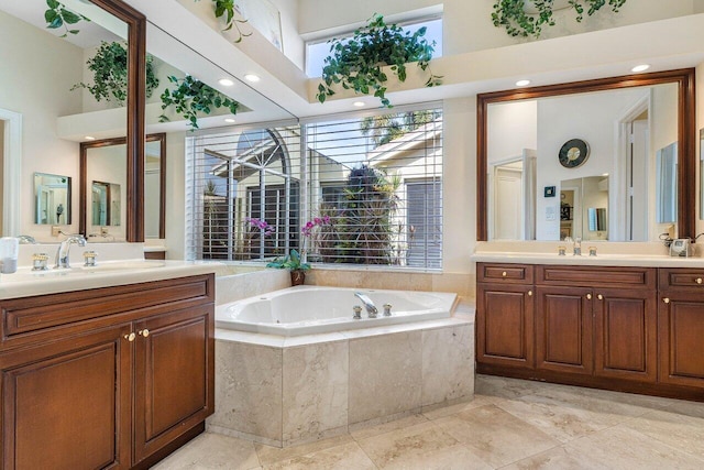 bathroom featuring vanity, a towering ceiling, and tiled bath