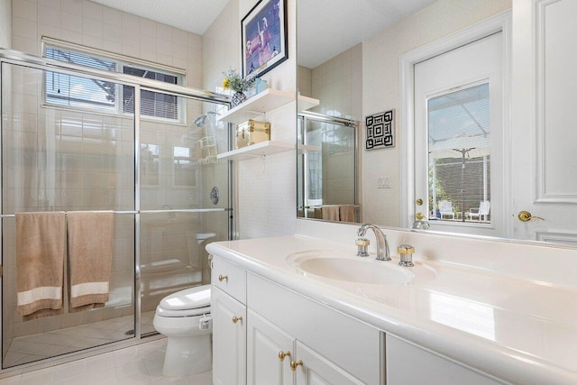 bathroom with tile patterned floors, vanity, toilet, and a shower with door