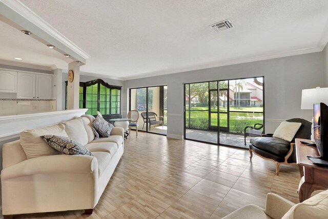 living room with a textured ceiling, light tile patterned floors, and crown molding