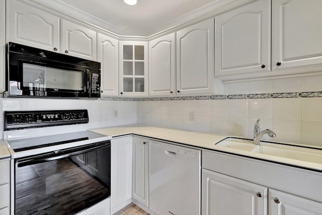 kitchen with backsplash, white appliances, sink, and white cabinetry