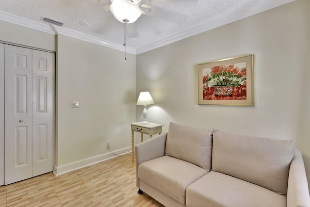 sitting room featuring a textured ceiling, crown molding, and ceiling fan