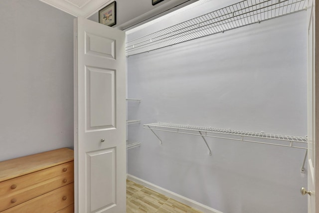 walk in closet with light hardwood / wood-style floors