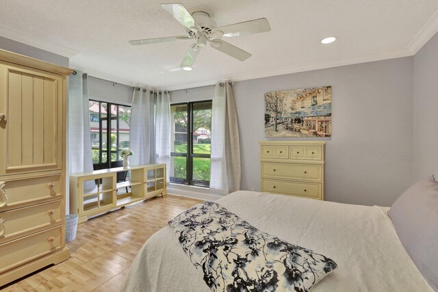 bedroom featuring ceiling fan, ornamental molding, a textured ceiling, and light hardwood / wood-style floors