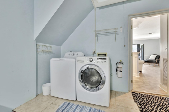 laundry room featuring light tile patterned floors and separate washer and dryer