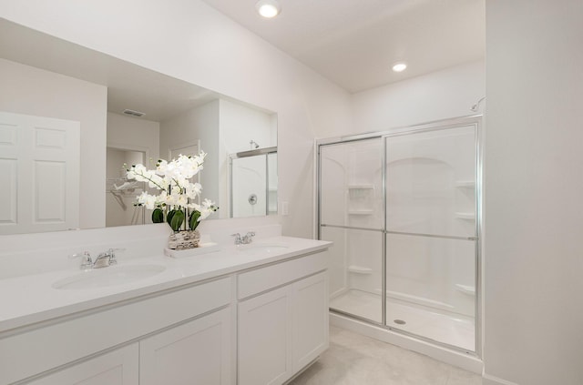 bathroom with tile patterned flooring, vanity, and walk in shower