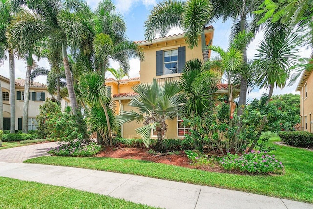 mediterranean / spanish-style home with a front yard