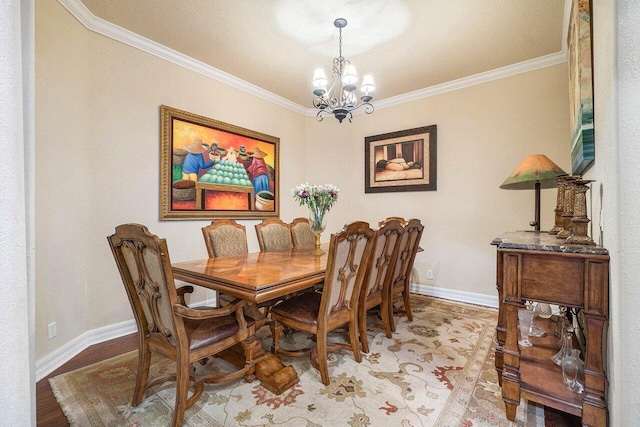 dining area featuring an inviting chandelier, ornamental molding, and light wood-type flooring