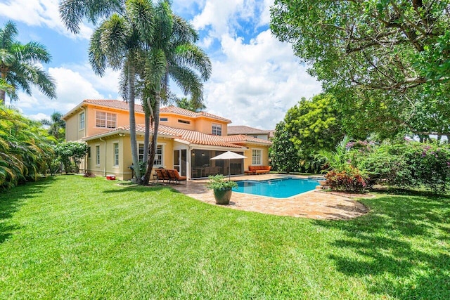 rear view of house featuring a patio area and a lawn