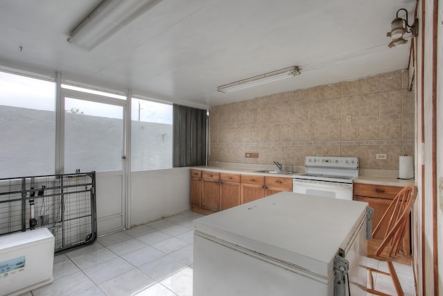 kitchen featuring sink, tile walls, light tile patterned floors, and white electric stove