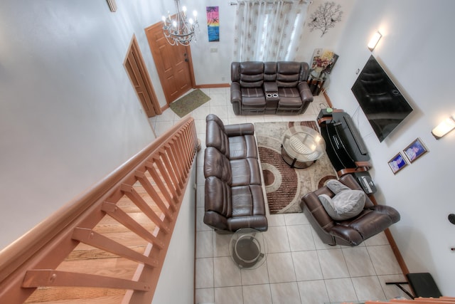 living room with a notable chandelier, tile patterned floors, and a high ceiling