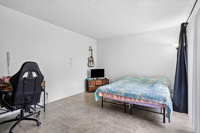 bedroom featuring tile patterned floors and a textured ceiling