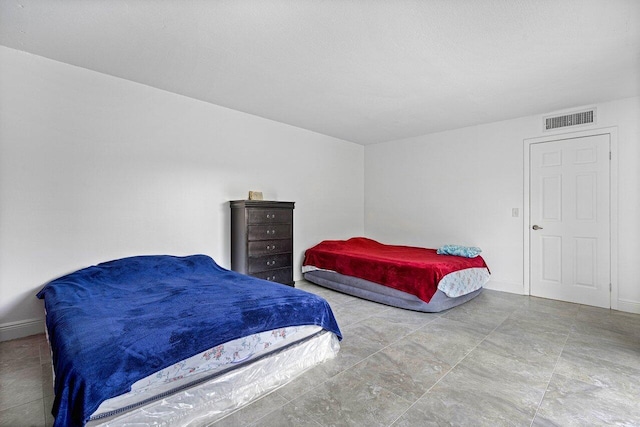 bedroom with baseboards and visible vents