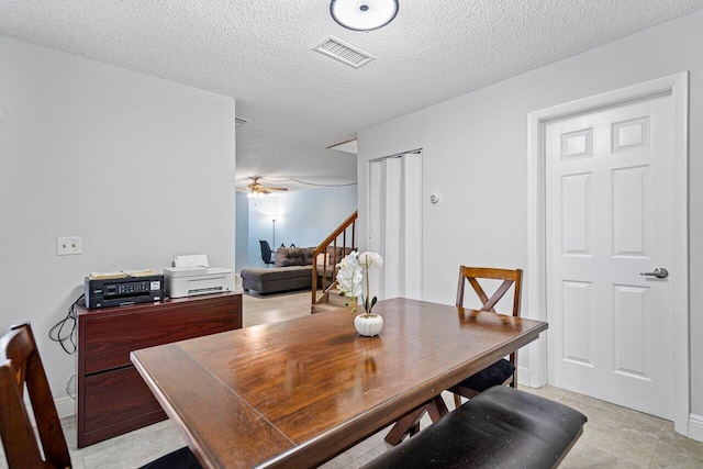 tiled dining space featuring ceiling fan and a textured ceiling