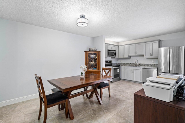 dining area featuring a textured ceiling and baseboards