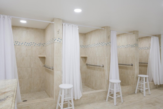 bathroom with tile patterned floors, walk in shower, and tile walls