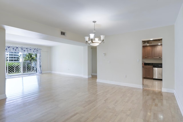 unfurnished living room with an inviting chandelier and light hardwood / wood-style flooring