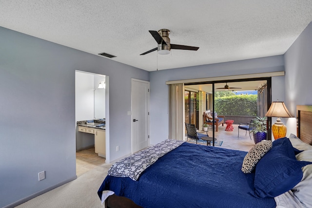 bedroom with a textured ceiling, access to outside, light colored carpet, ceiling fan, and ensuite bathroom