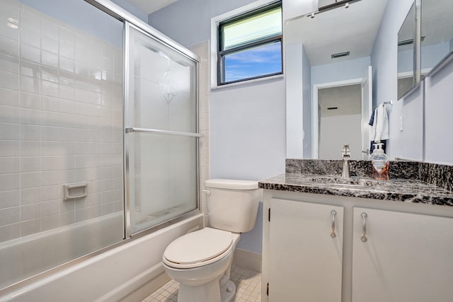 full bathroom featuring tile patterned floors, vanity, combined bath / shower with glass door, and toilet