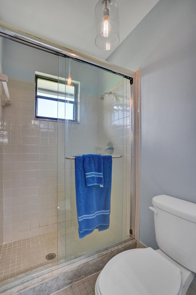 bathroom featuring an enclosed shower and toilet