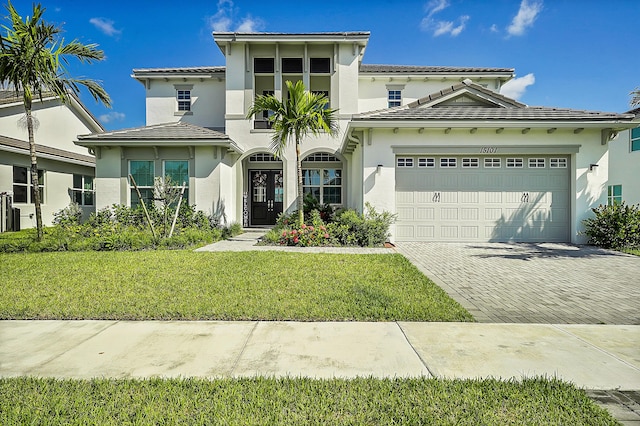 mediterranean / spanish-style house with a garage and a front lawn