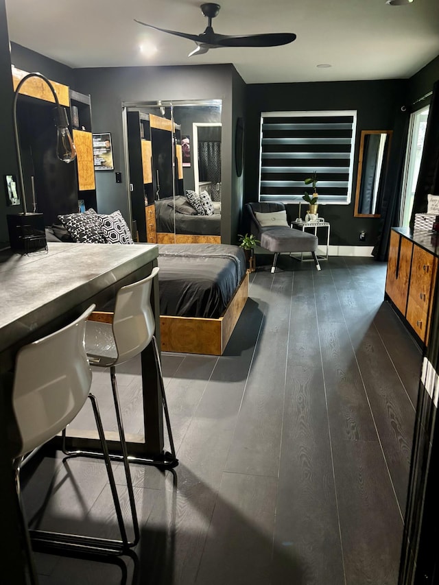 bedroom with ceiling fan and dark wood-type flooring