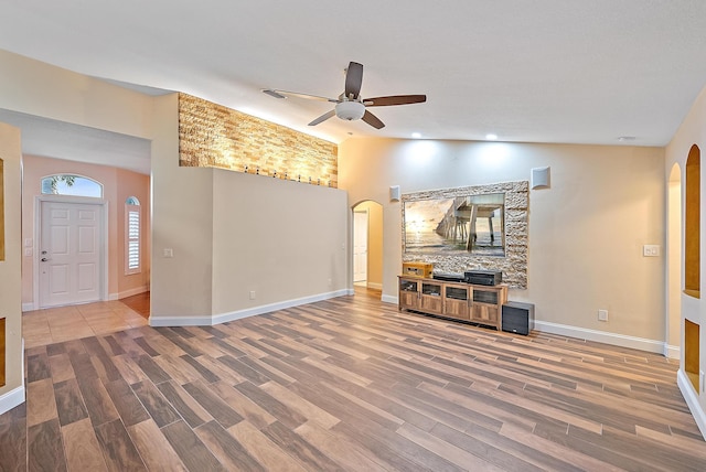 unfurnished living room with ceiling fan, lofted ceiling, and hardwood / wood-style floors