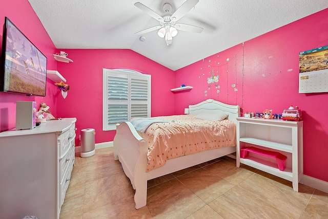 tiled bedroom featuring a textured ceiling, ceiling fan, and lofted ceiling