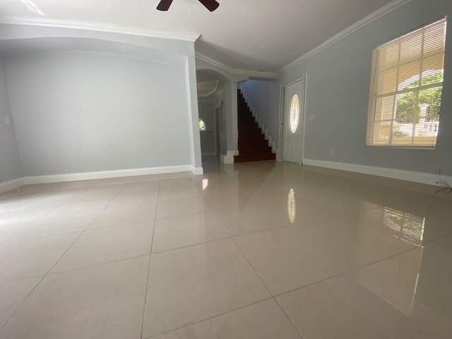 unfurnished room with ceiling fan, ornamental molding, and light tile patterned flooring