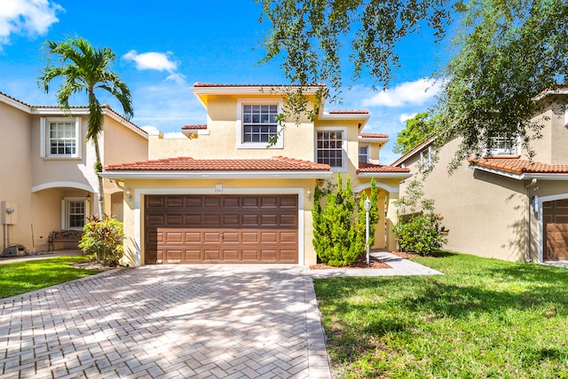 mediterranean / spanish home featuring a garage and a front lawn