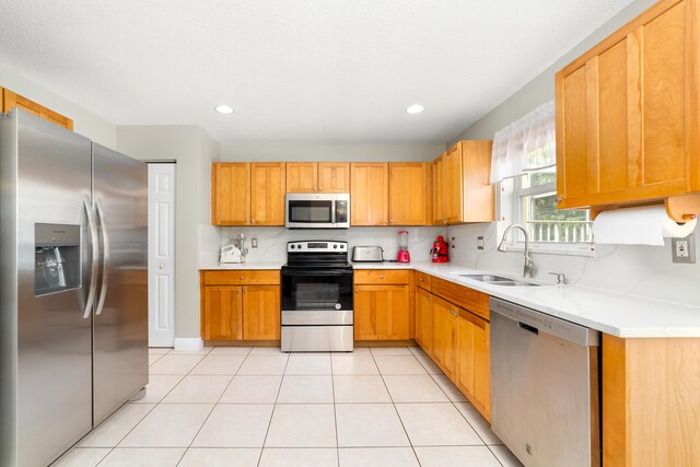 kitchen featuring sink, stainless steel appliances, light tile patterned flooring, and tasteful backsplash