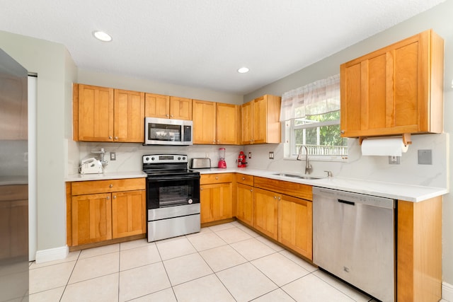 kitchen featuring light tile patterned floors, sink, and stainless steel appliances