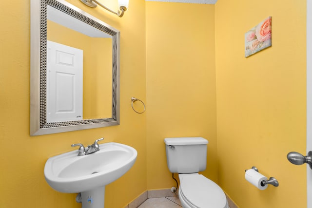 bathroom with sink, toilet, and tile patterned floors