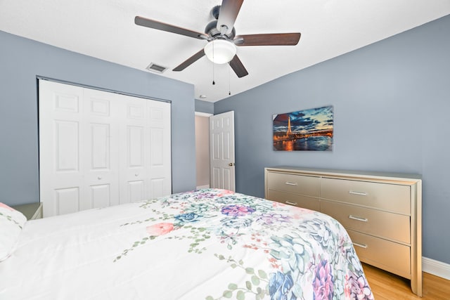 bedroom with ceiling fan, a closet, and light hardwood / wood-style floors