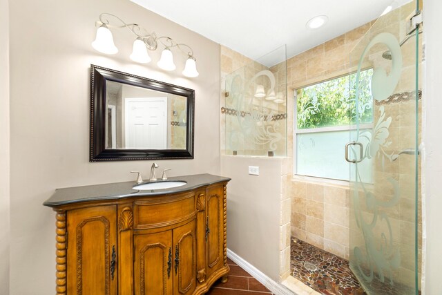 bathroom featuring tile patterned flooring, a shower with door, and vanity