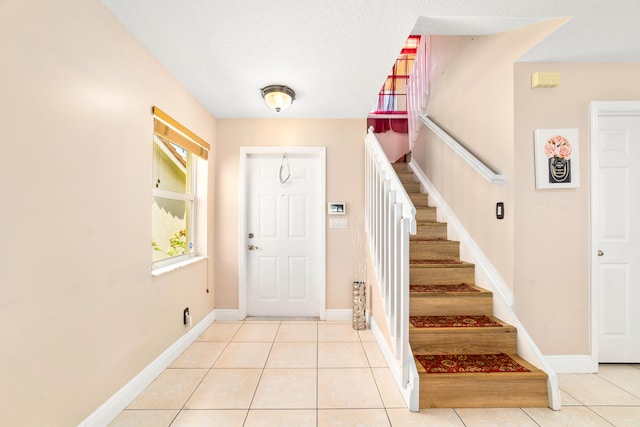 tiled entrance foyer featuring a textured ceiling