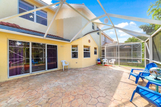 exterior space with a patio and glass enclosure