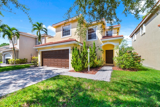 mediterranean / spanish home featuring a garage and a front yard