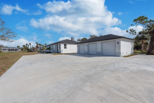 view of home's exterior with an outbuilding, a detached garage, and stucco siding