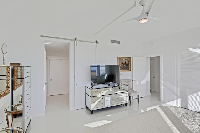 tiled living room with ceiling fan and a barn door