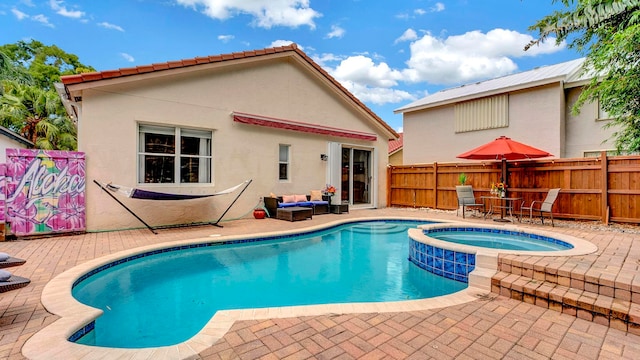 view of pool featuring an outdoor living space, an in ground hot tub, and a patio area