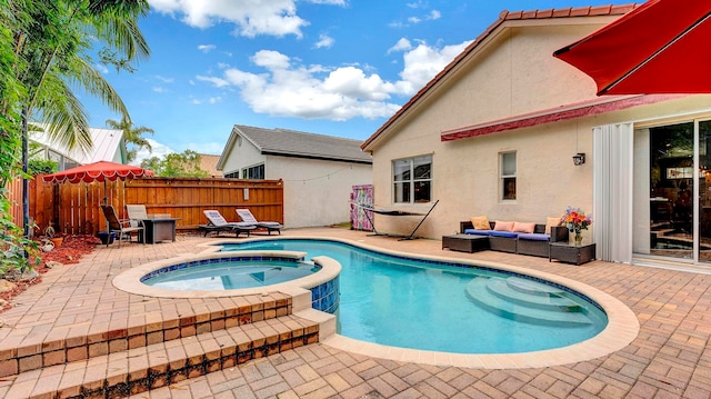 view of pool featuring an in ground hot tub, outdoor lounge area, and a patio area