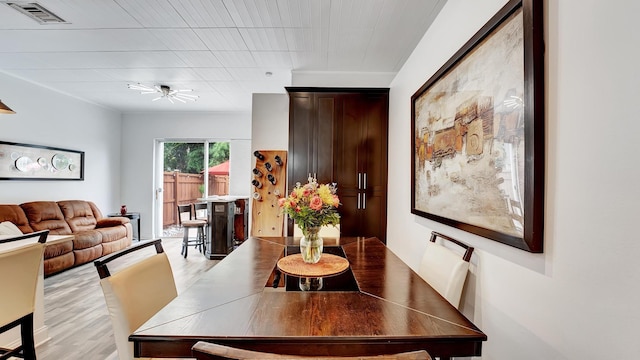 dining space with ceiling fan and light hardwood / wood-style flooring