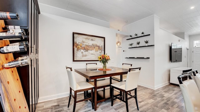 dining room featuring light hardwood / wood-style floors and crown molding