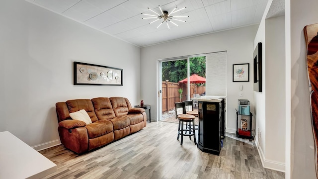 living room featuring hardwood / wood-style floors, crown molding, and an inviting chandelier